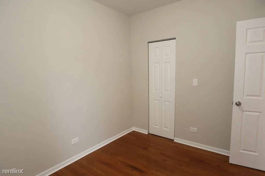 3916 West Altgeld Street, Unit 1 Chicago, IL 60647 - Photo 16 of 18 an empty room with wooden floor and closet