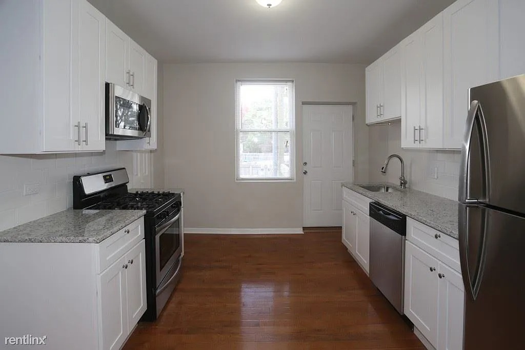 3916 West Altgeld Street, Unit 1 Chicago, IL 60647 - Photo 2 of 18 a kitchen with granite countertop a refrigerator stove and sink