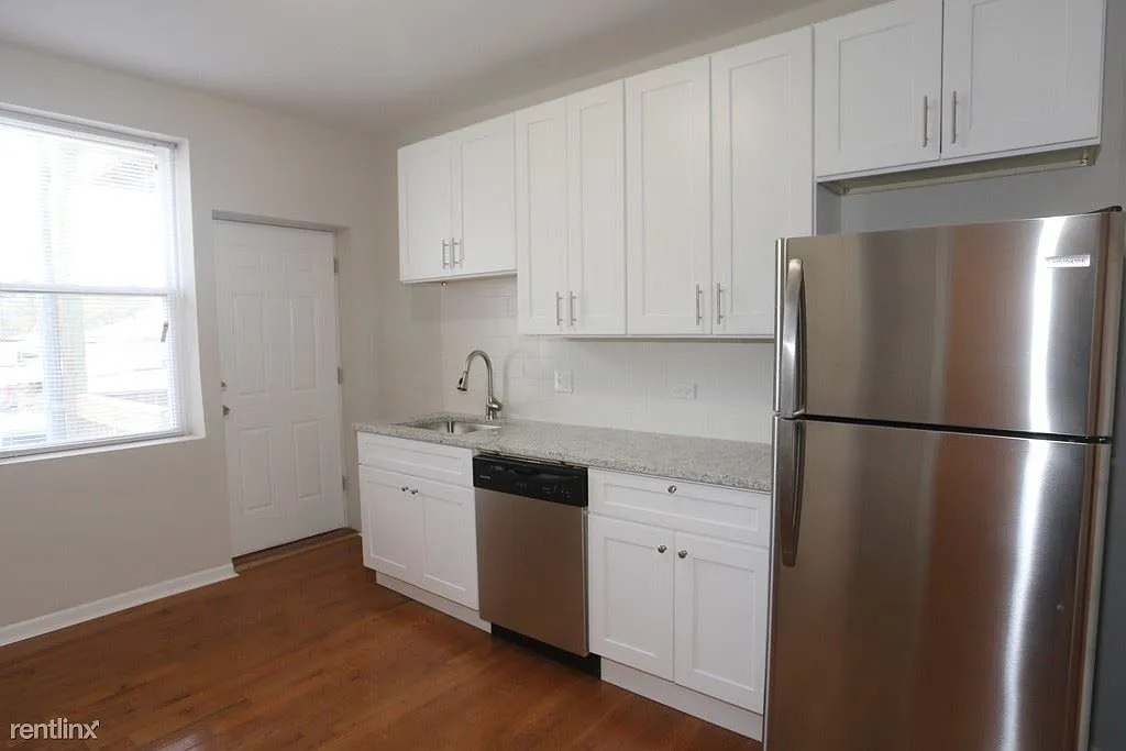 3916 West Altgeld Street, Unit 1 Chicago, IL 60647 - Photo 4 of 18 a kitchen with stainless steel appliances white cabinets and a refrigerator