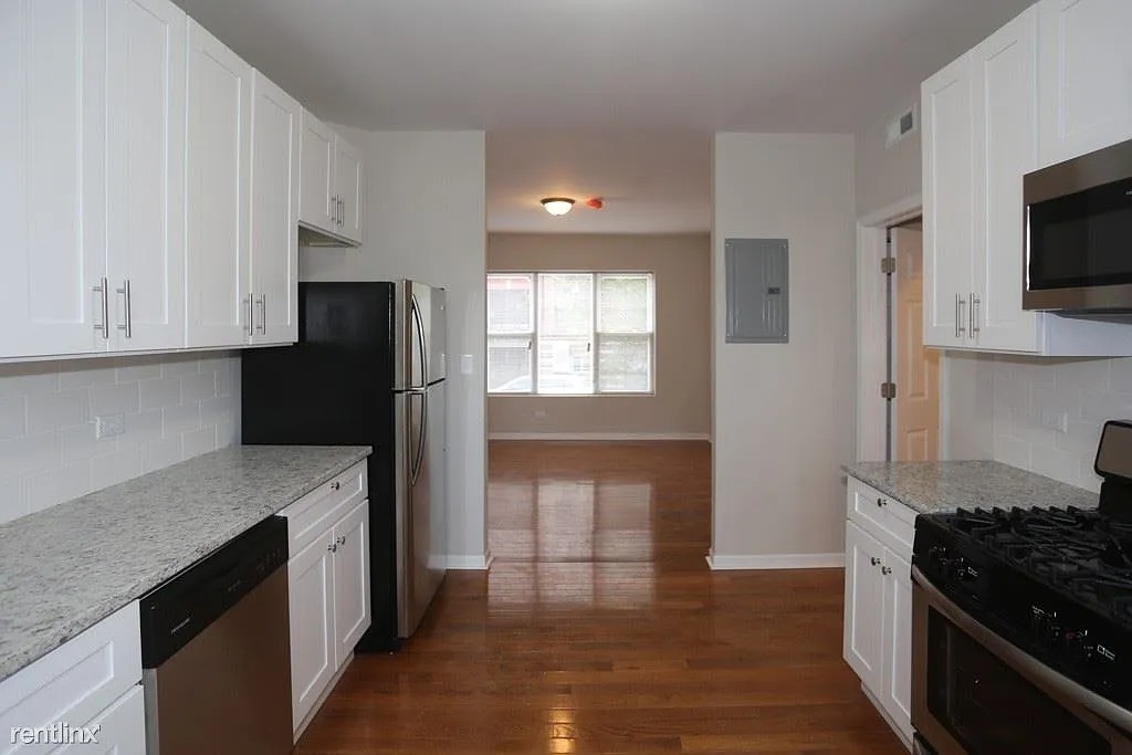 3916 West Altgeld Street, Unit 1 Chicago, IL 60647 - Photo 6 of 18 a kitchen with stainless steel appliances granite countertop a refrigerator and a stove top oven