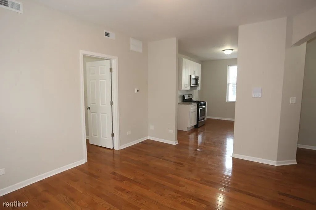 3916 West Altgeld Street, Unit 1 Chicago, IL 60647 - Photo 10 of 18 a view of empty room with wooden floor and a window