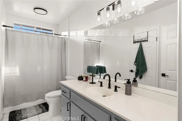 a bathroom with a double vanity sink mirror and toilet