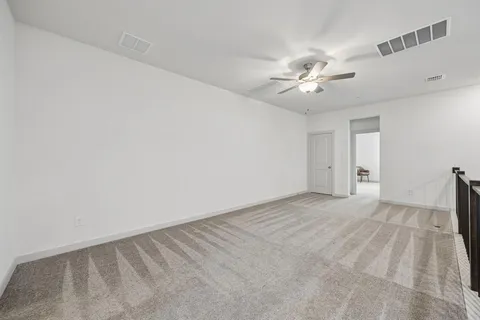 a view of an empty room with a ceiling fan