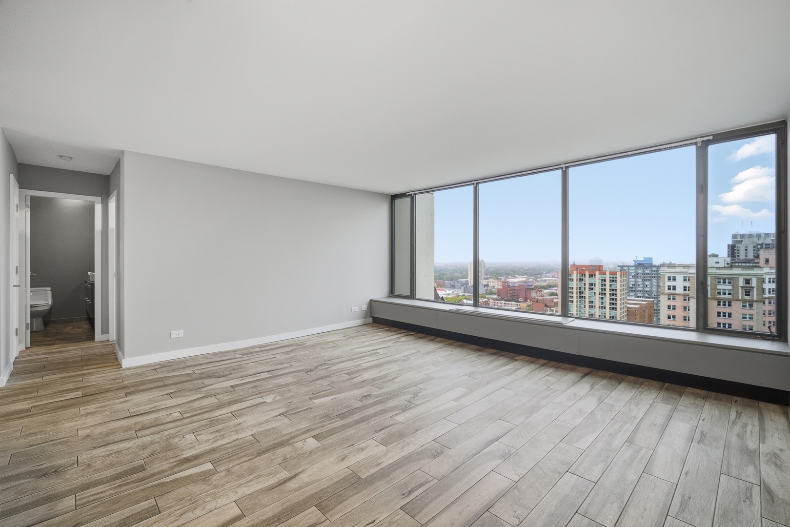 5455 North Sheridan Road, Unit 2611 Chicago, IL 60640 - Photo 15 of 26 a view of an empty room with a window and wooden floor