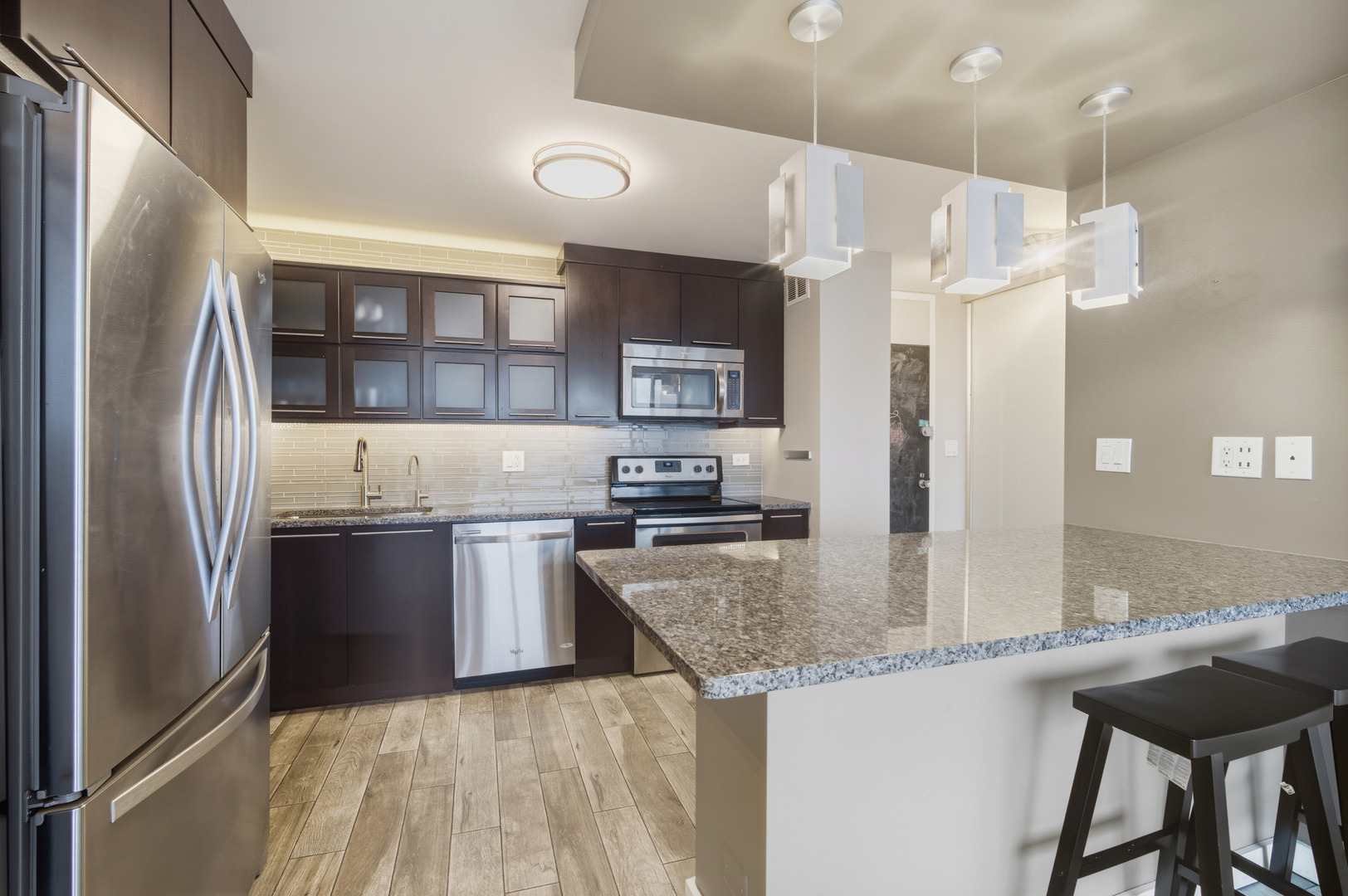 5455 North Sheridan Road, Unit 2611 Chicago, IL 60640 - Photo 7 of 26 a kitchen with granite countertop a refrigerator stove top oven and sink