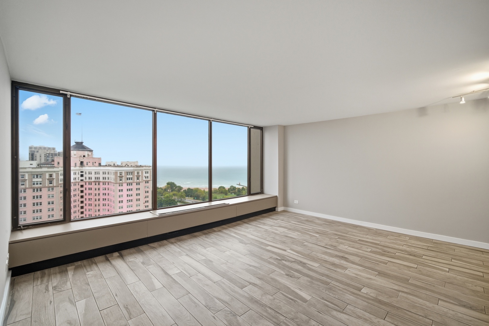 5455 North Sheridan Road, Unit 2611 Chicago, IL 60640 - Photo 9 of 26 an empty room with wooden floor and windows
