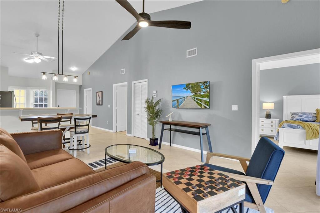 9165 Celeste Drive, Unit 3303 Naples, FL 34113 - Photo 11 of 26 a living room with a couch and a chandelier