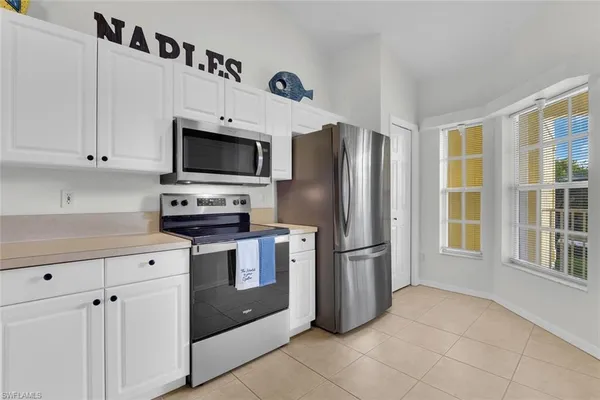a dining room with furniture a large window and chandelier