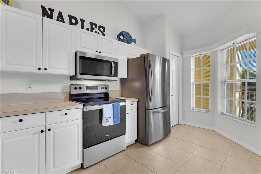 9165 Celeste Drive, Unit 3303 Naples, FL 34113 - Photo 5 of 26 a kitchen with stainless steel appliances a refrigerator stove and microwave