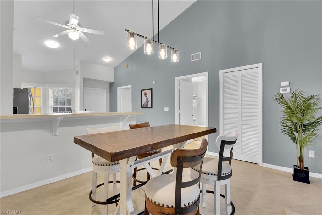 9165 Celeste Drive, Unit 3303 Naples, FL 34113 - Photo 8 of 26 a view of a dining room with furniture and a chandelier fan