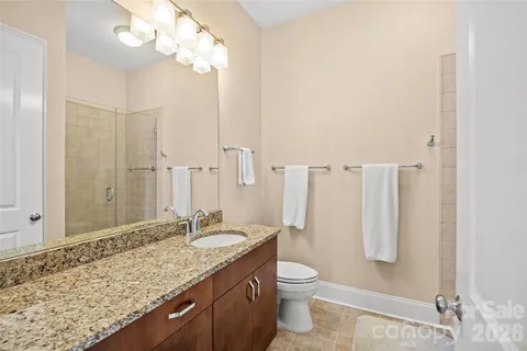 a bathroom with a granite countertop sink toilet and shower