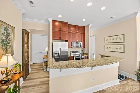 a large kitchen with kitchen island a counter top space a sink and stainless steel appliances