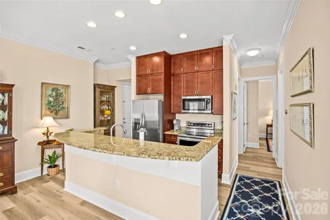 a kitchen with stainless steel appliances granite countertop a refrigerator a stove and a sink