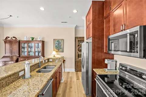 a kitchen with stainless steel appliances granite countertop a stove a sink and a refrigerator