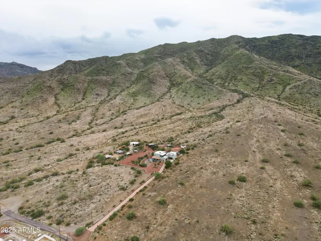 a view of a dry field with mountains in the background