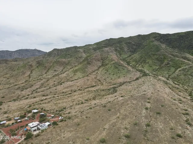a view of a dry field with mountains in the background