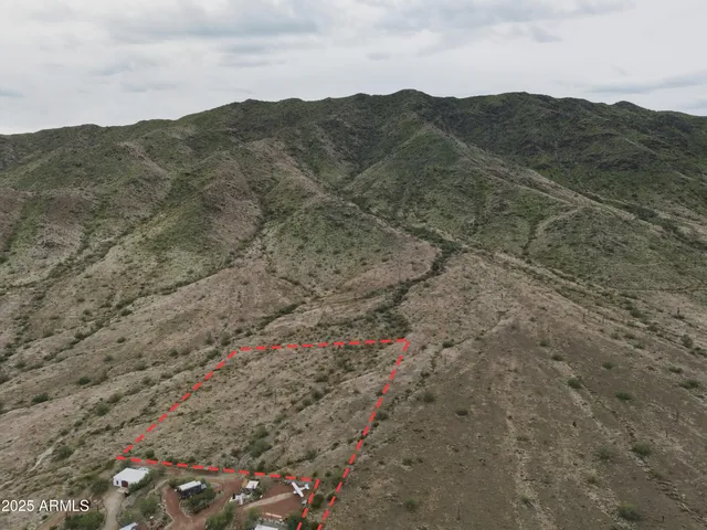 a view of a dry field with mountains in the background