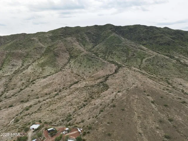 a view of a dry field with mountains in the background