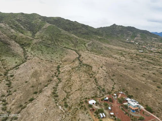 a view of a dry field with mountains in the background