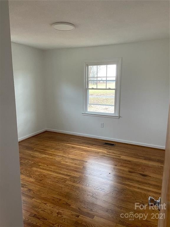 107 Keeter Street Grover, NC 28073 - Photo 7 of 9 an empty room with wooden floor and windows