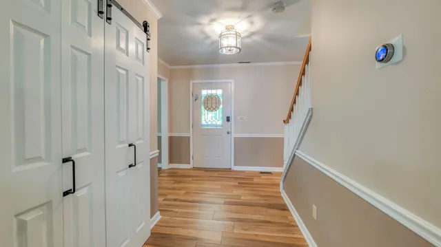 a view of a hallway with wooden floor and staircase