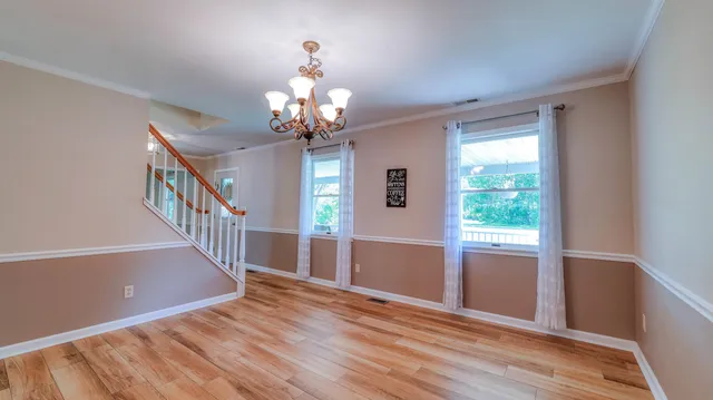 a view of a livingroom with wooden floor and stairs
