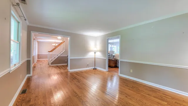 a view of empty room with wooden floor