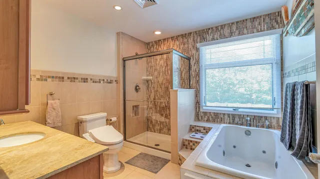 a bathroom with a sink a toilet and shower