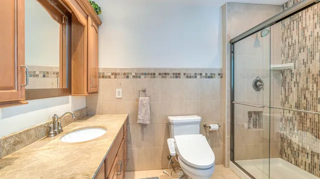 a bathroom with a granite countertop sink toilet and shower