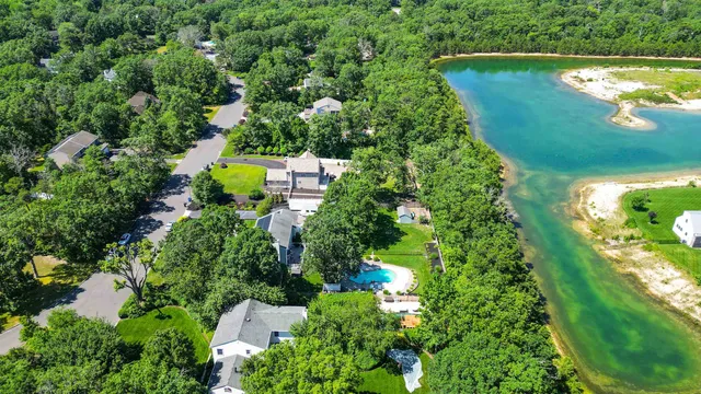an aerial view of a house with a yard and lake view