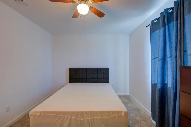 a white bed in a room next to a window