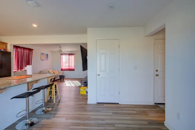a view of a kitchen with kitchen island stainless steel appliances wooden floor and view living room