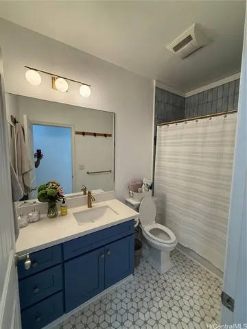 a bathroom with a double vanity sink toilet and mirror