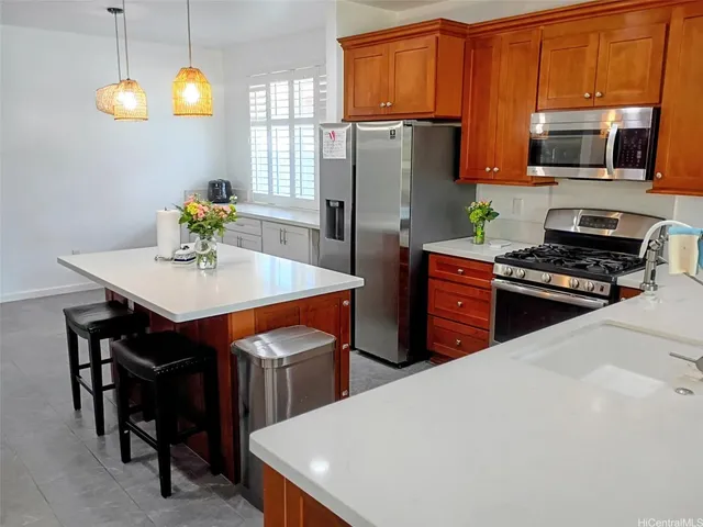 a kitchen with stainless steel appliances a stove a refrigerator a sink a stove a dining table and chairs