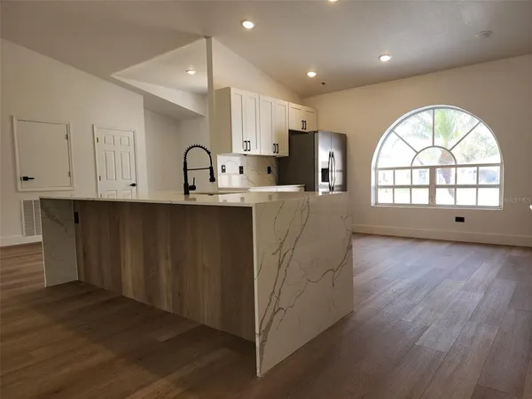 an open kitchen with wooden floor and window