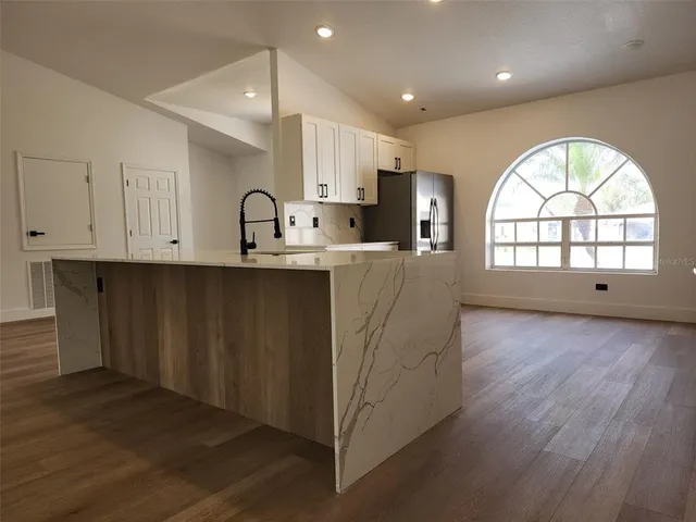 an open kitchen with wooden floor and window