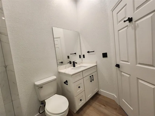 a bathroom with a toilet a sink a mirror and vanity