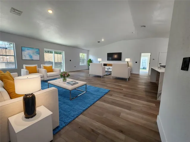 a living room with furniture and wooden floor