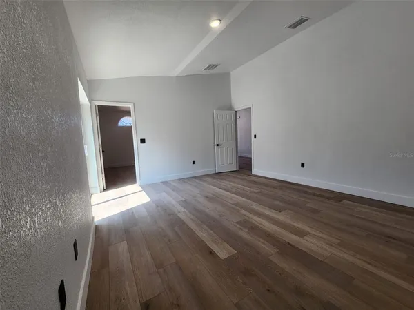 a view of an empty room with wooden floor