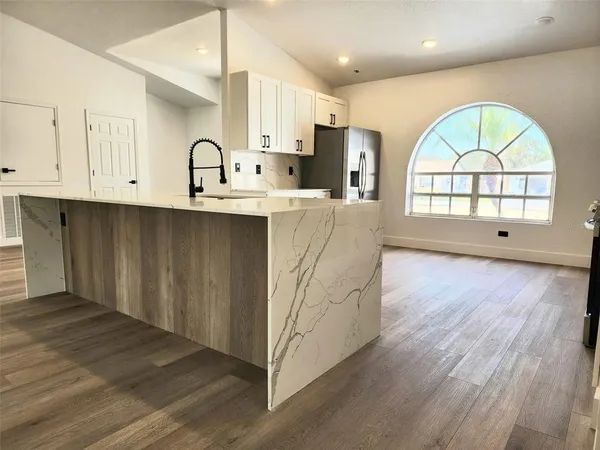 a view of kitchen with wooden floors and a window