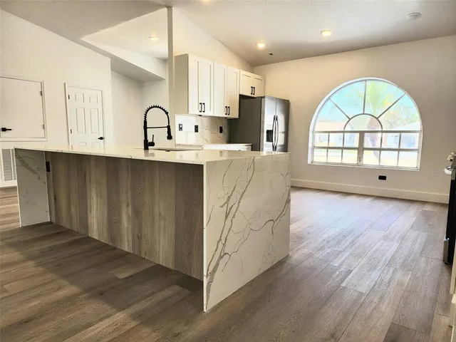 a view of kitchen with wooden floors and a window