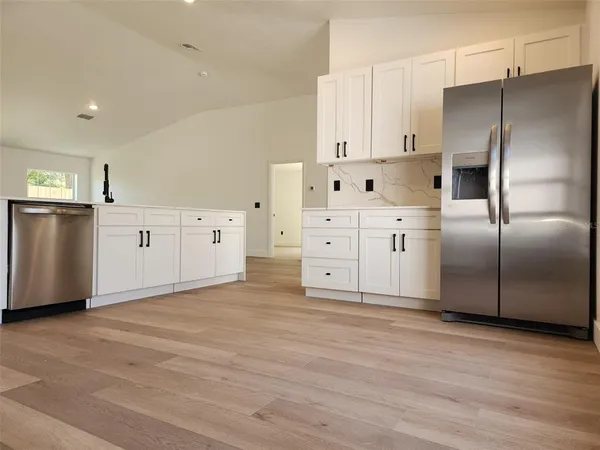 a kitchen with stainless steel appliances a refrigerator sink and cabinets