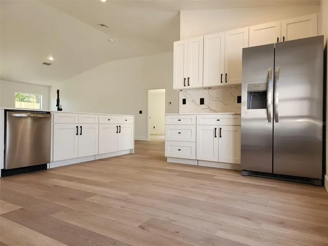 a kitchen with stainless steel appliances a refrigerator sink and cabinets