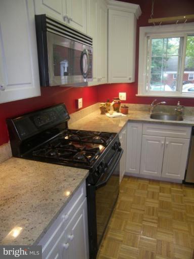 3648 Gunston Road Alexandria, VA 22302 - Photo 2 of 12 a kitchen with stainless steel appliances granite countertop a stove a sink and a microwave