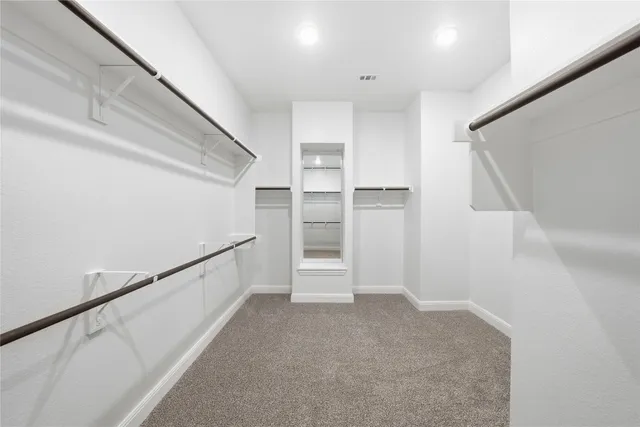 a view of walk in closet with empty racks