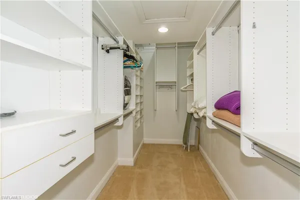 a view of walk in closet with clothes and shoes
