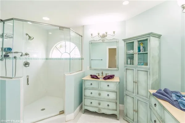 a bathroom with a mirror shower vanity and a sink