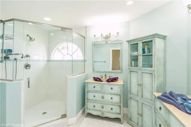 a bathroom with a mirror shower vanity and a sink
