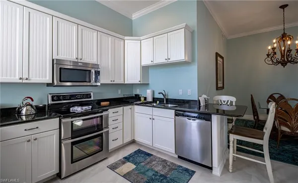 a kitchen with stainless steel appliances granite countertop a stove a sink and a microwave