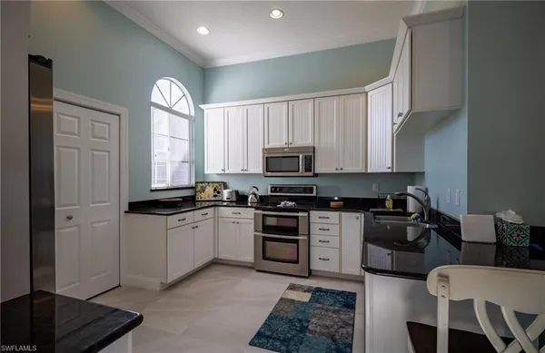 a kitchen with stainless steel appliances granite countertop a stove a sink and a refrigerator